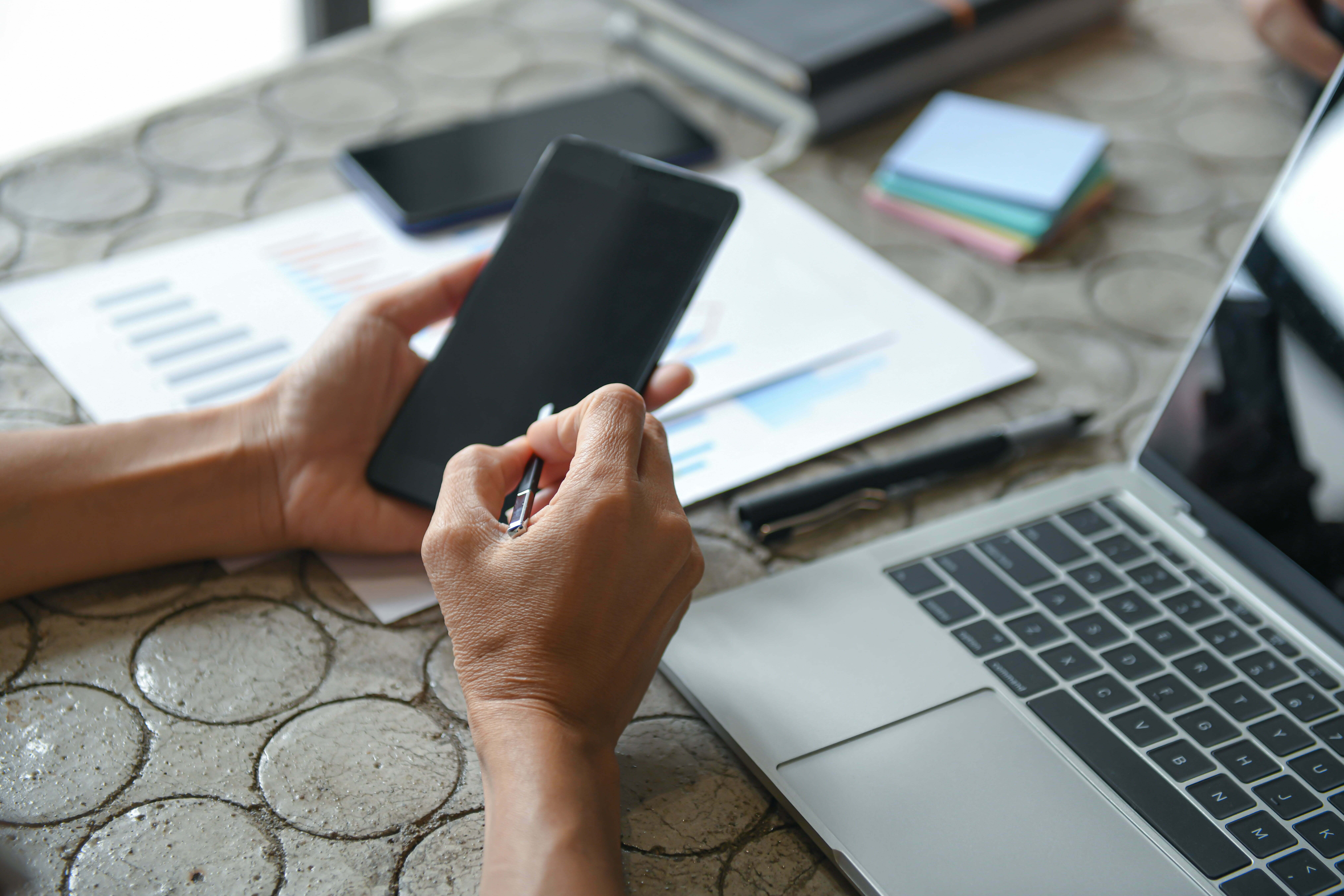 Hand of a business woman is using a mobile phone to find information.